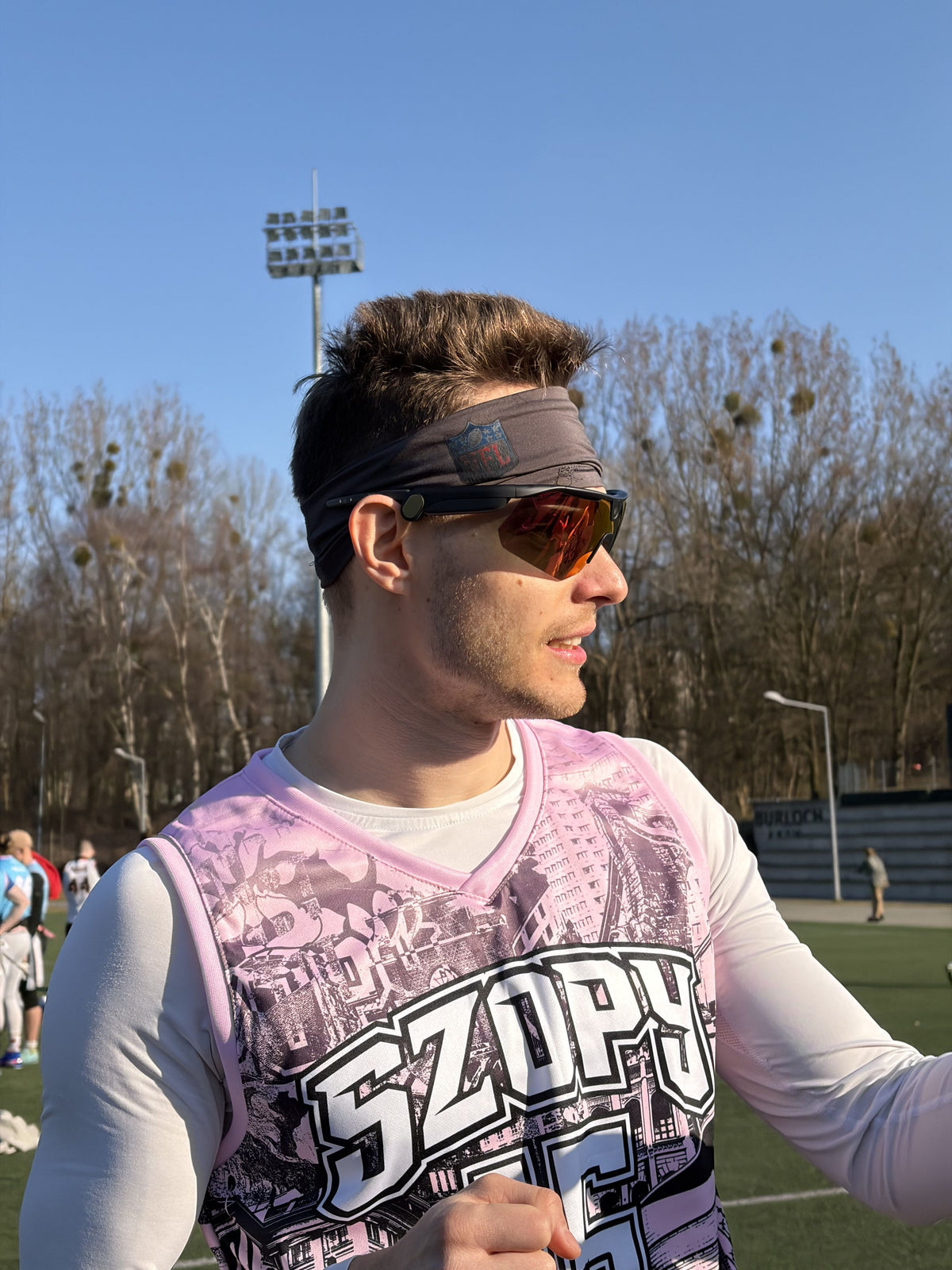 A man is wearing a gray headband featuring an NFL shield logo on the front.